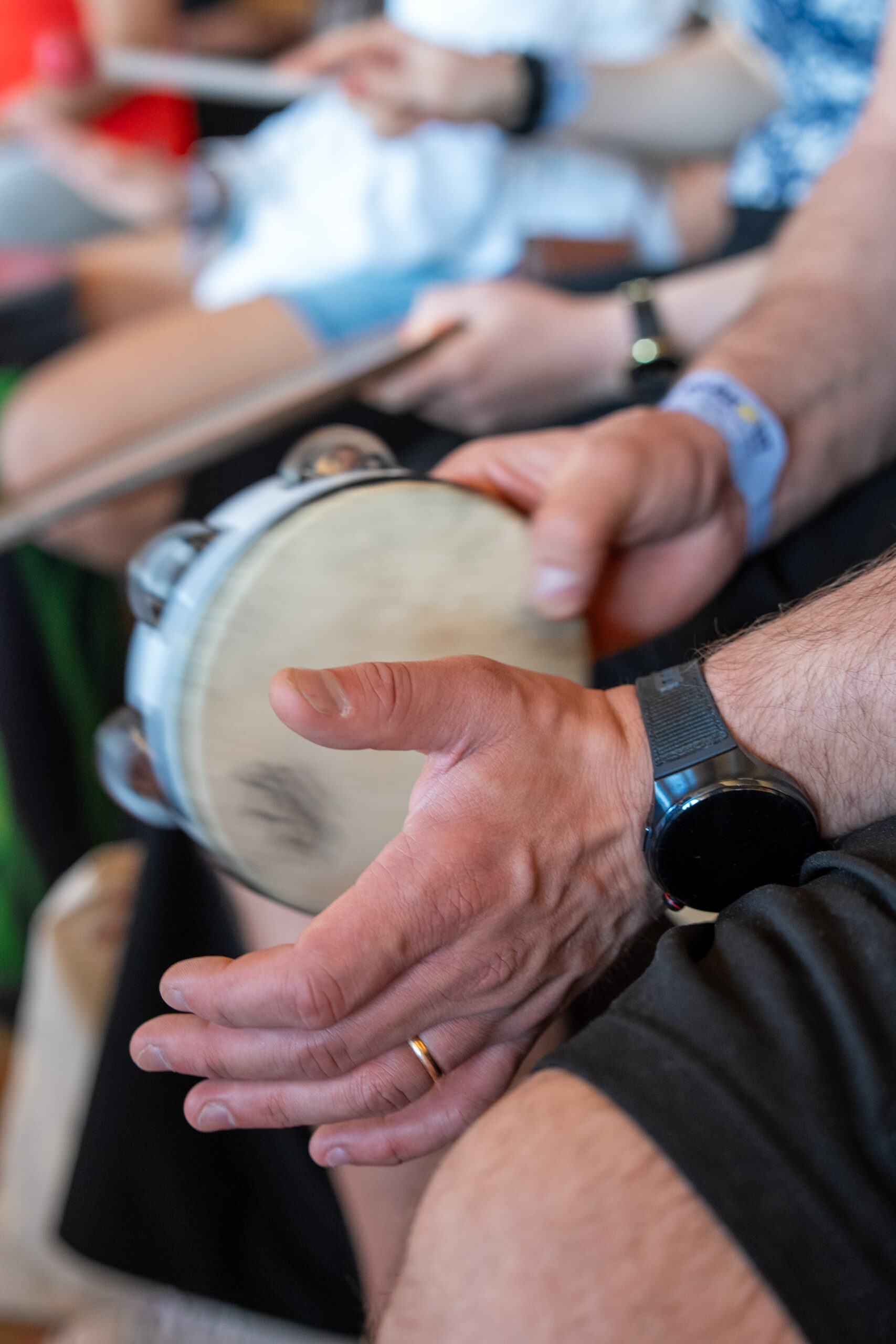Percussions collectives à Ibiza Gros plan sur les mains de plusieurs participants frappant un tambour lors d’une activité de cohésion d’équipe à Ibiza, organisée par Julievents.