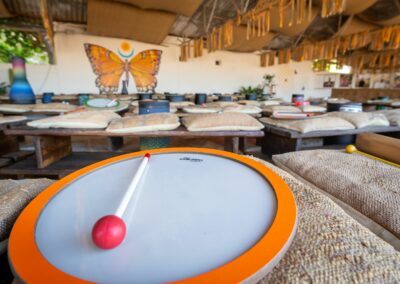Tambour au sol dans un espace naturel à Ibiza, entouré de participants réunis pour une activité de team building en percussion.