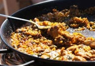 Atelier de préparation de paella lors d’un séminaire et team building à Ibiza, activité culinaire et fédératrice organisée par JuliEvents